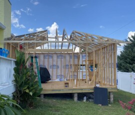 Wall and roof truss framing Timber wall framing and roof trusses against a blue sky